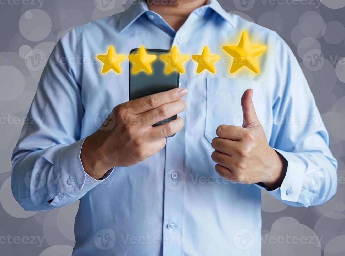 Man give a thumb up on mobile phone for comment review five star. photo
