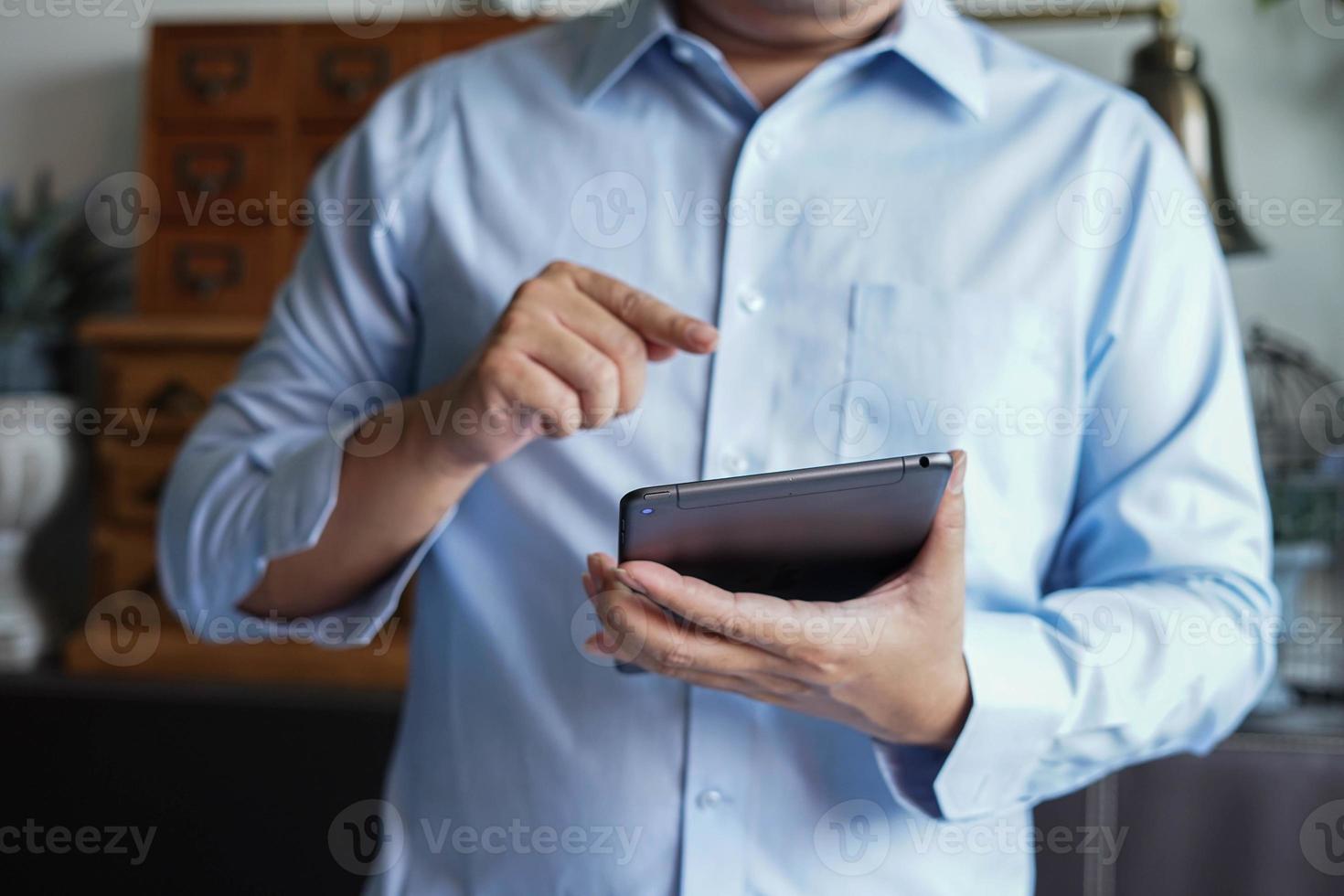 hombre usando y sosteniendo la mano en una tableta de teléfono móvil. foto