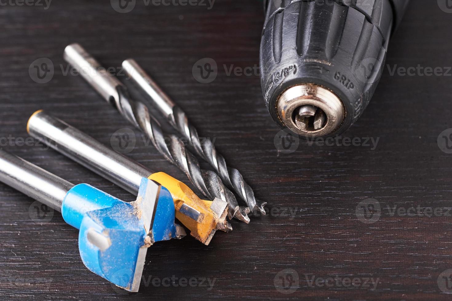 Different kind of drill bit on a wooden background photo