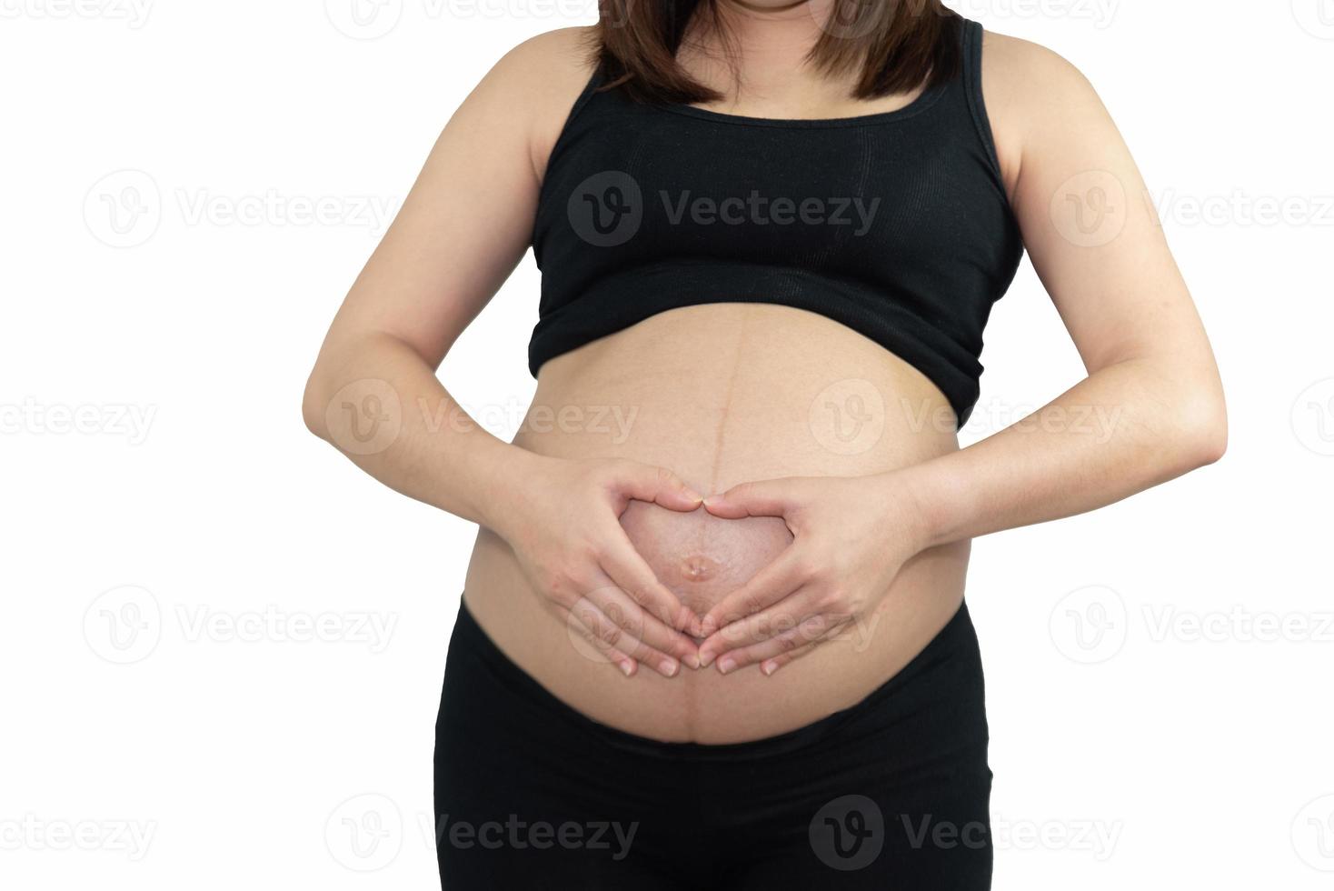 Pregnant woman holding on her belly making hand heart shape isolated on white background. Family mother mom pregnant concept. photo