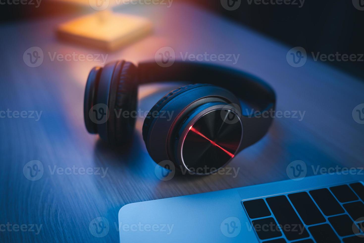 Headphone on the table at home studio for recording and laptop using recording software to make music night light. Music production concept. photo