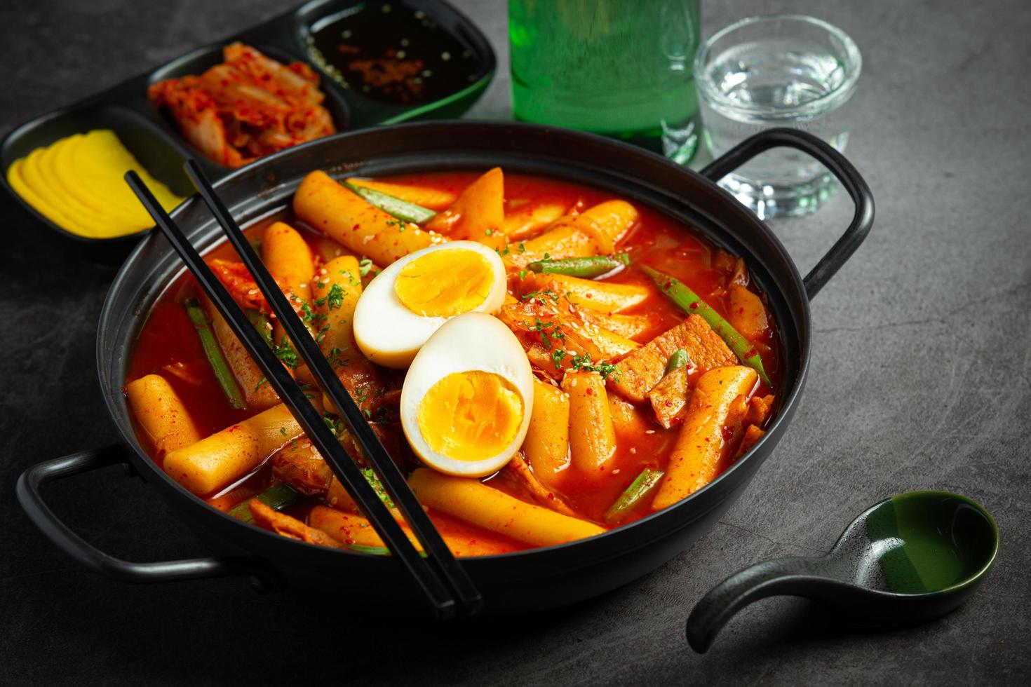 Cheesy Tokbokki korean traditional food on black board background. Lunch dish. photo