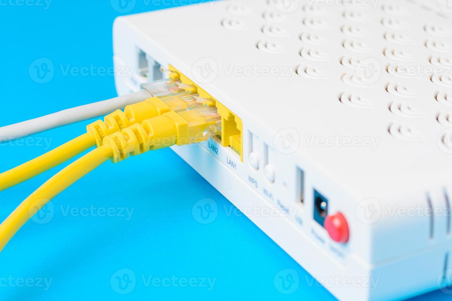 home wireless router with ethernet cables plugged in, closeup photo