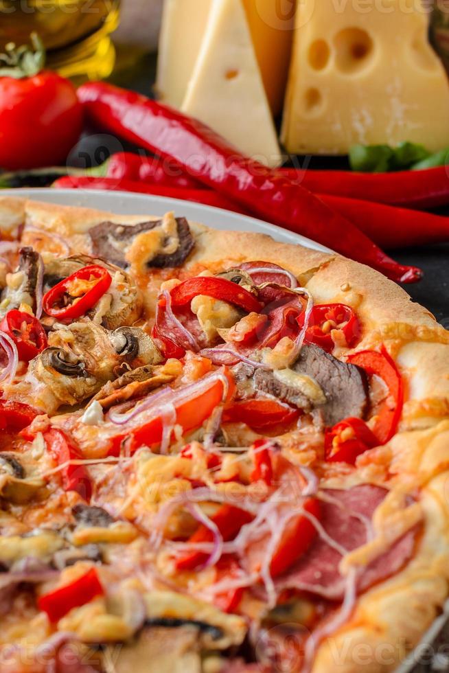 Mexican spicy pizza and ingredients on a wooden table. Traditional Italian cuisine. Party food photo