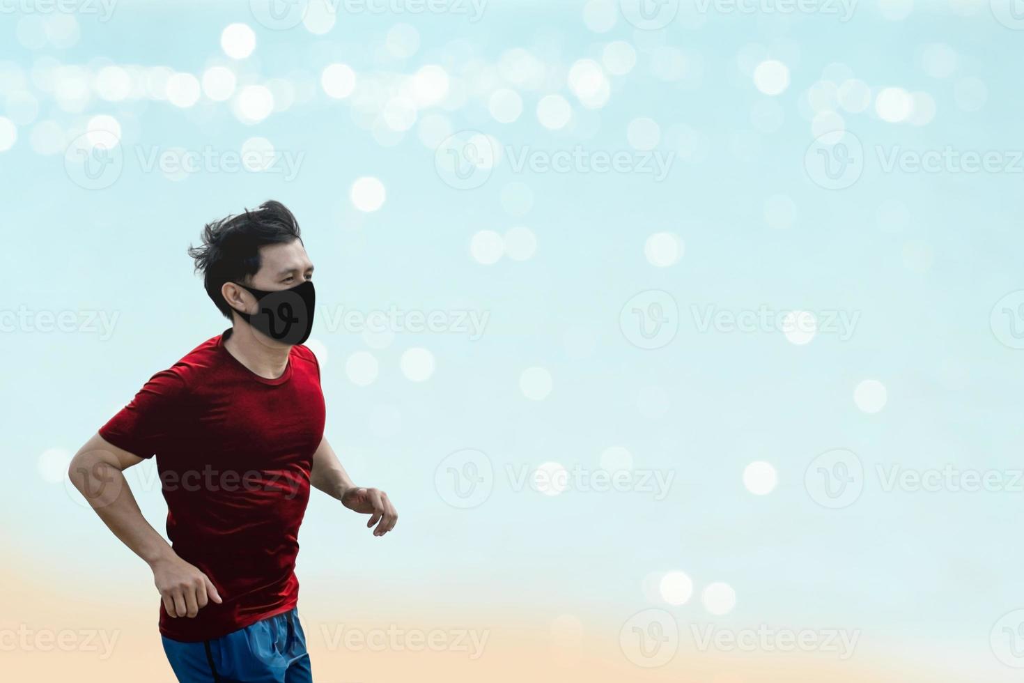 Asian man running and exercise with wearing a protective mask COVID-19 an outdoor workout on the beach. photo