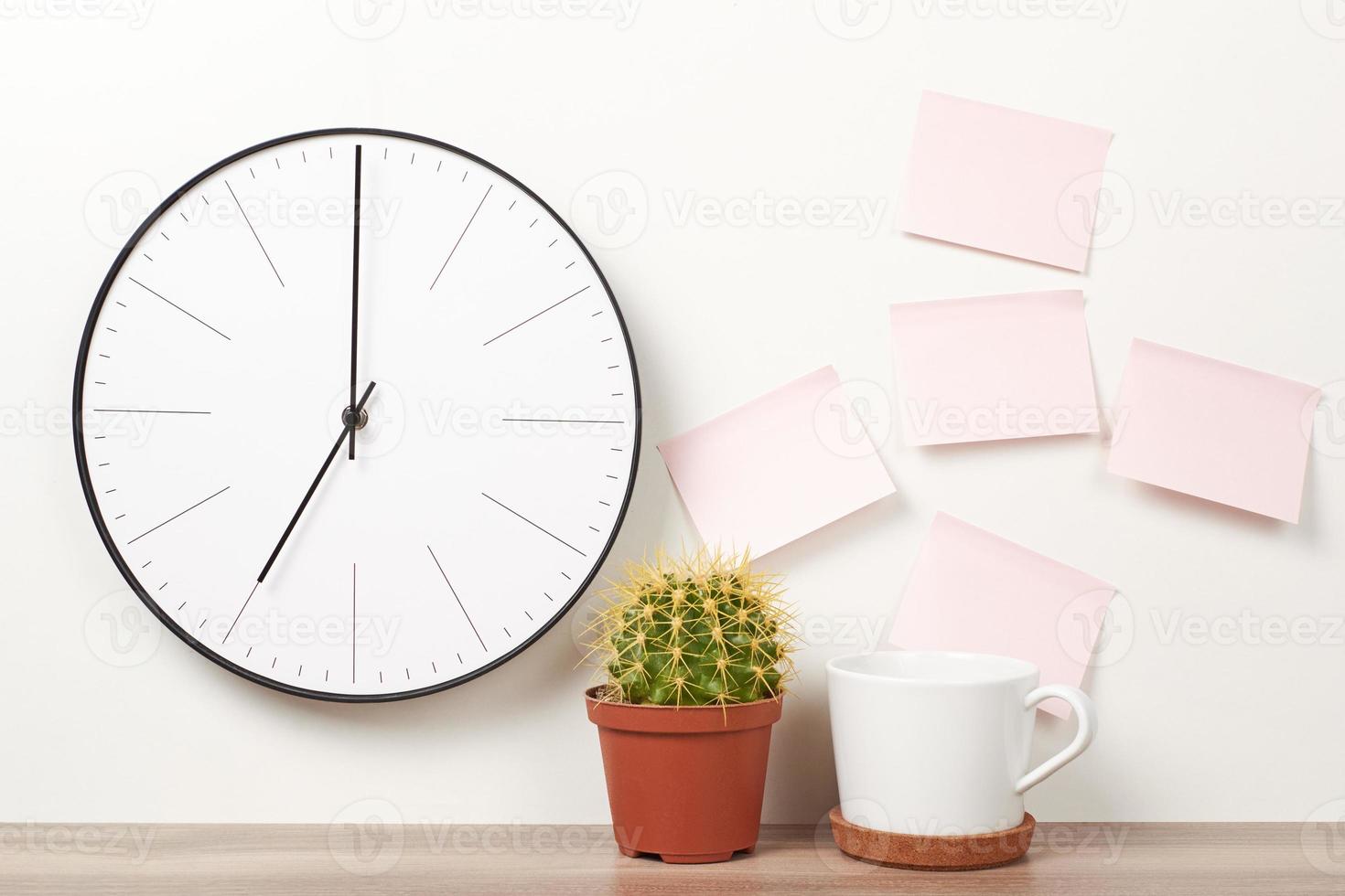 Wall clock, pink stickers, cactus and cup on a white background. Workspace mock up photo