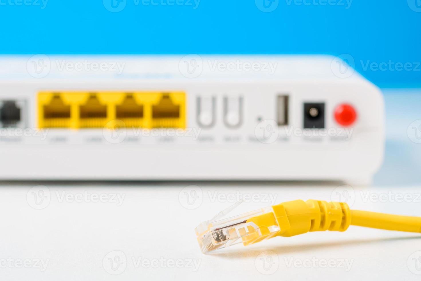 unplugged ethernet cable and internet router on a blue background photo