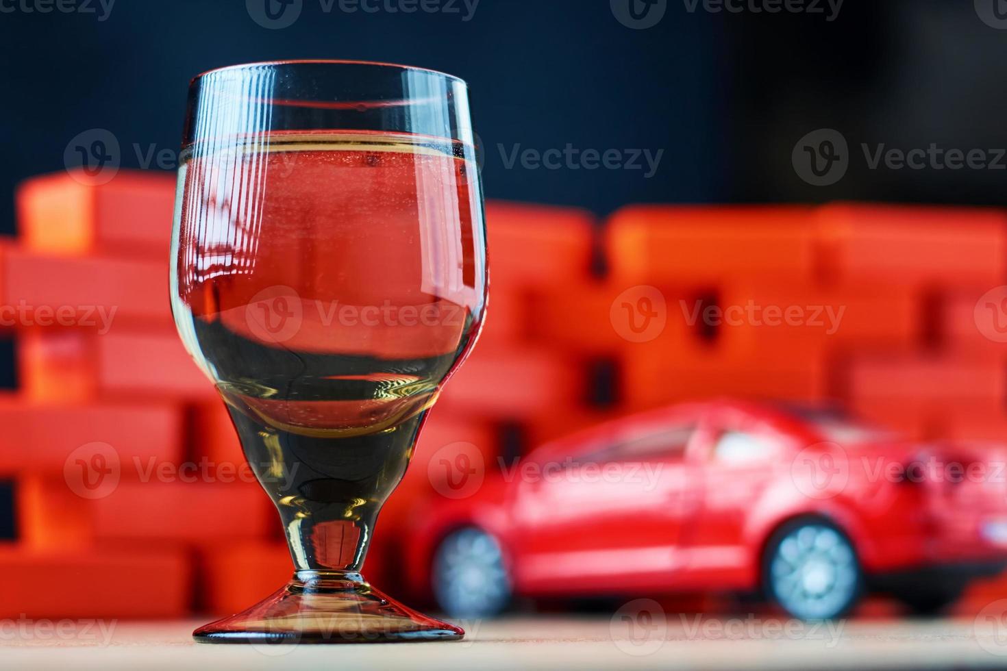 Drunk driving car crash accident. Don't drive after drink concept. Shot glass and a broken car photo