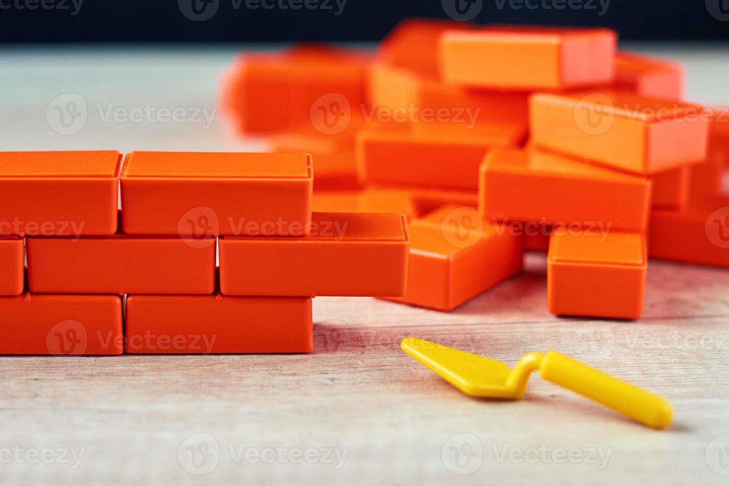 Brickwork from toy blocks and trowel. Unfinished construction concept photo