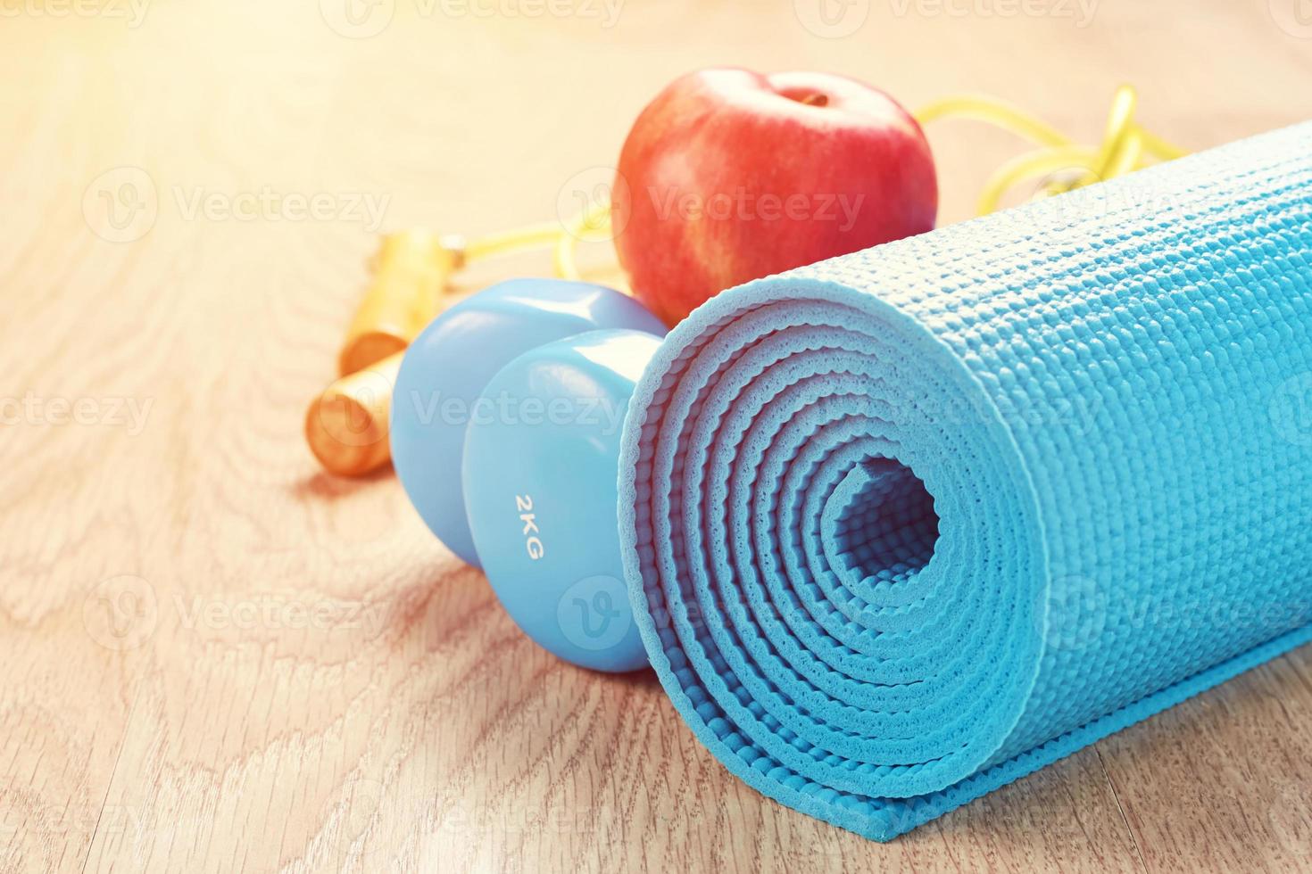 concepto de fitness con pesas azules y colchoneta de yoga foto