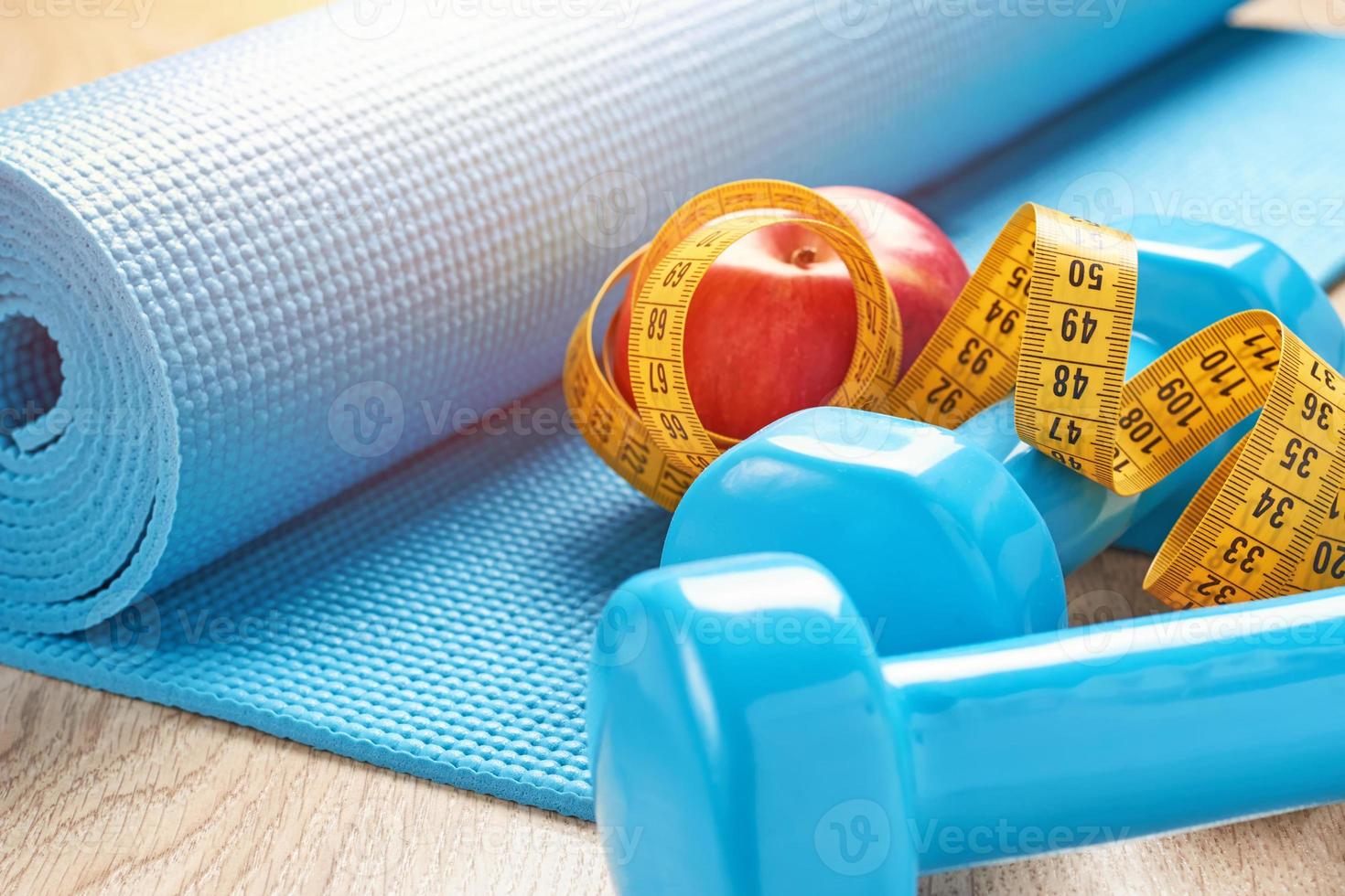 Fitness concept with blue dumbbells, fitness mat and a measuring tape photo