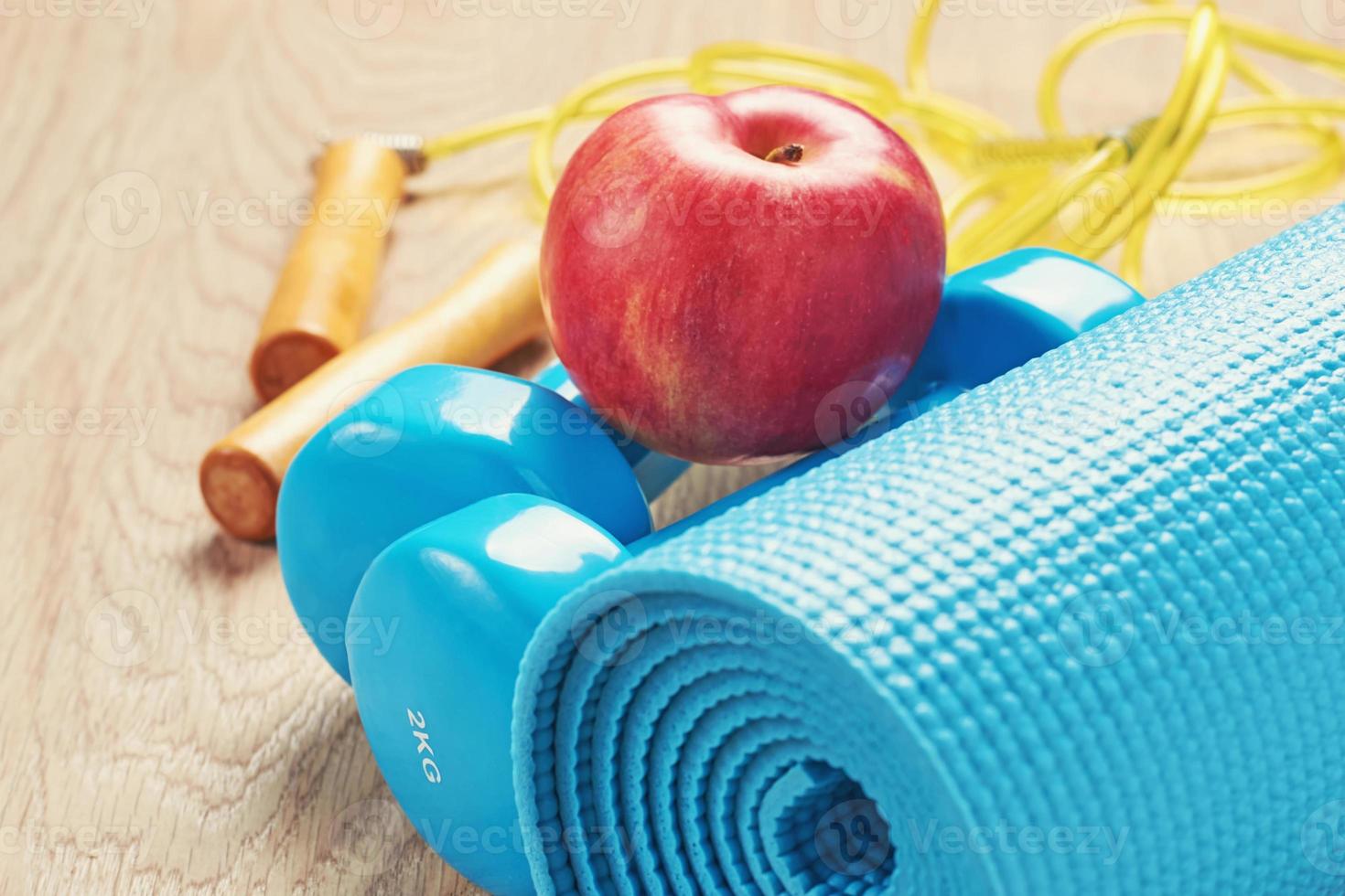 concepto de fitness con pesas azules y colchoneta de yoga foto