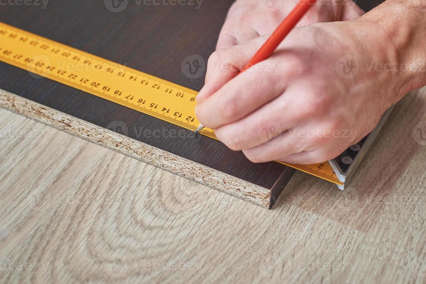 carpintero manos tomando medidas de tablones de madera, primer plano foto