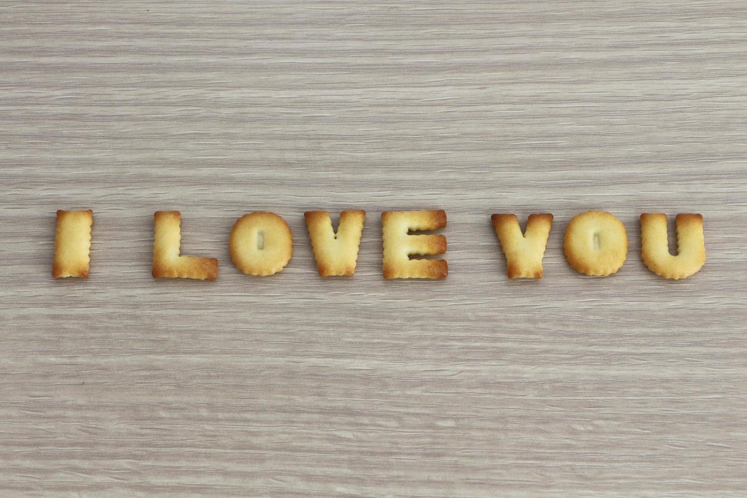 I LOVE YOU sentence arranged with cookies ABC on white oak wooden background for valentine's day. photo