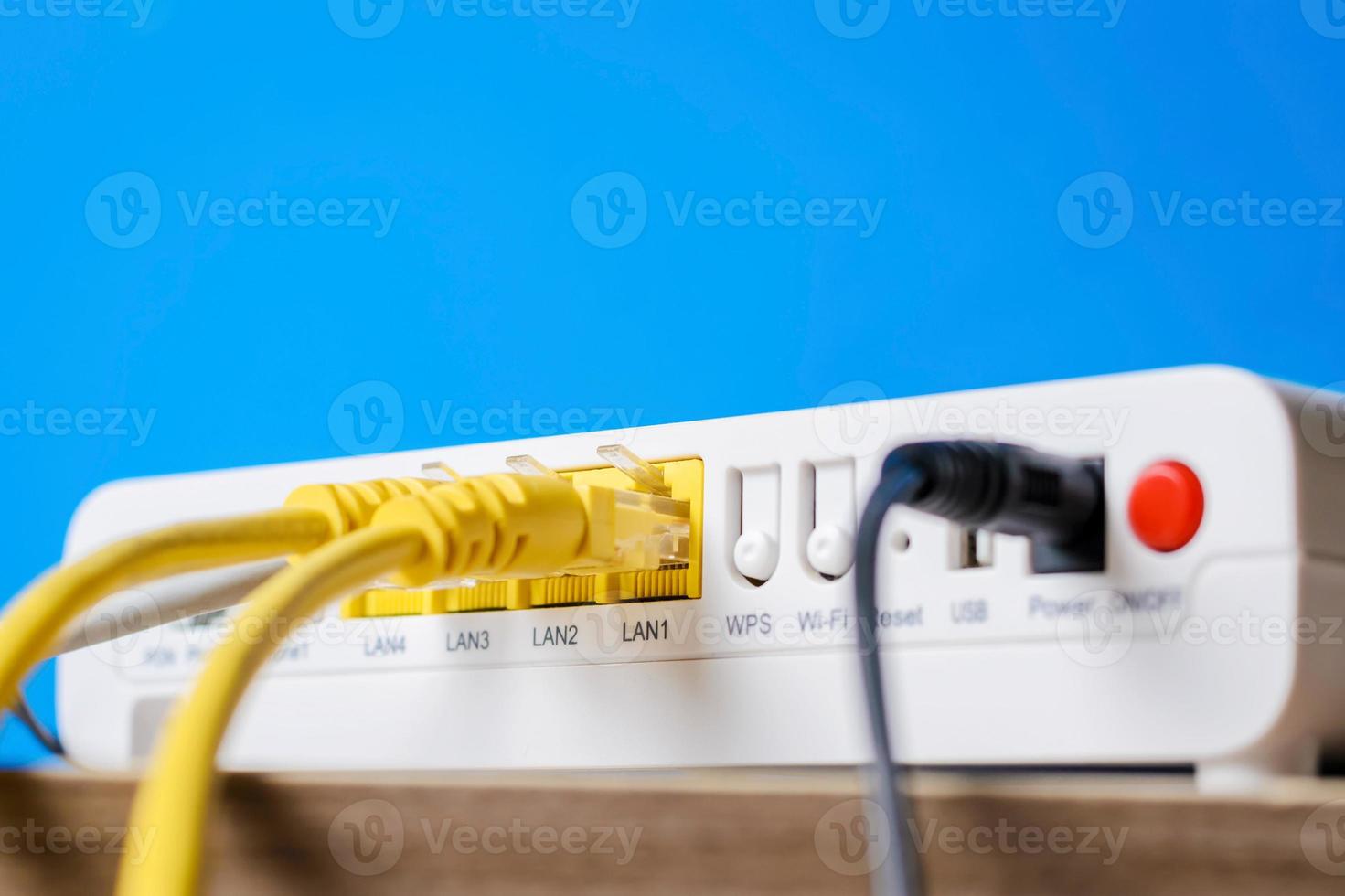 home wireless router with ethernet cables plugged in, closeup photo