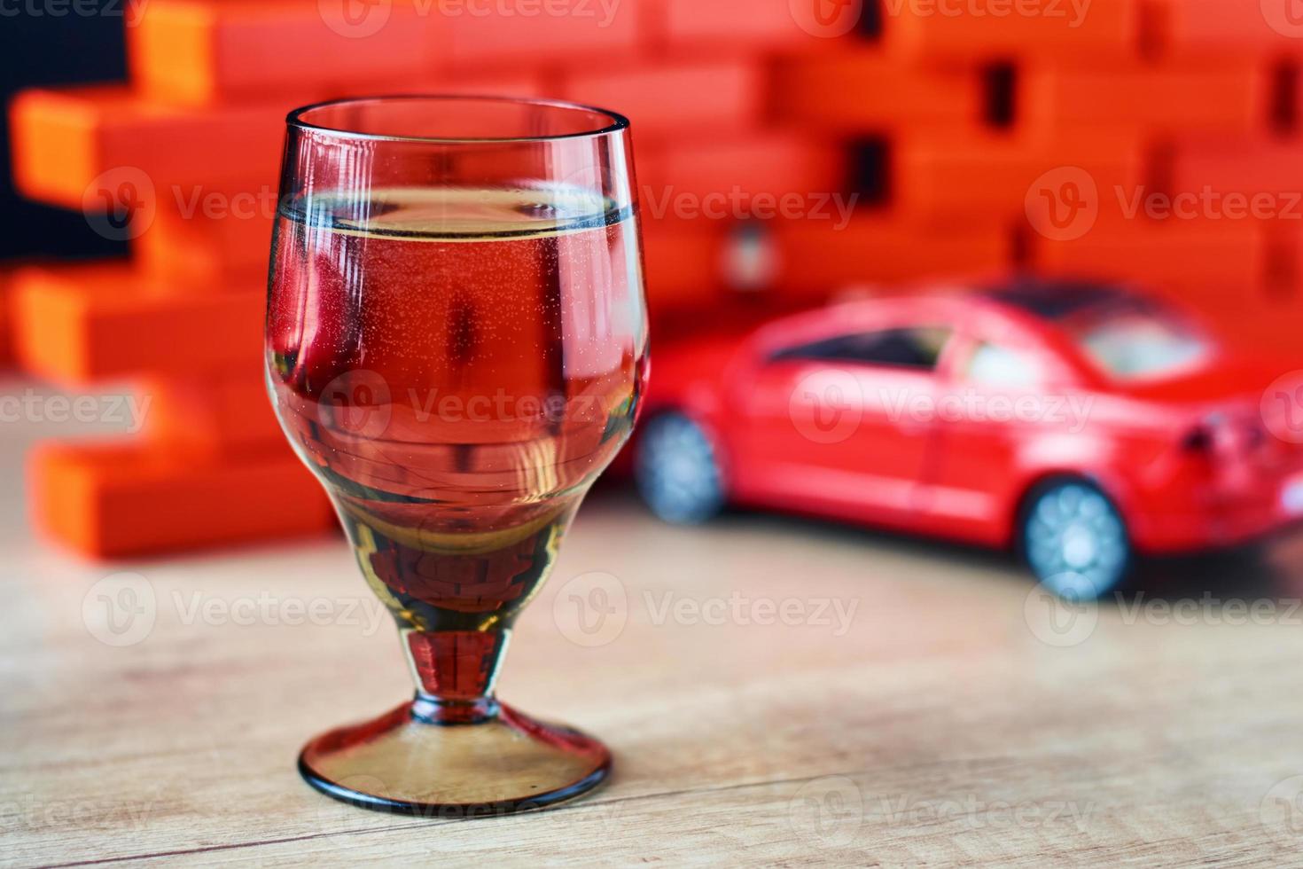 Drunk driving car crash accident. Don't drive after drink concept. Shot glass and a broken car photo