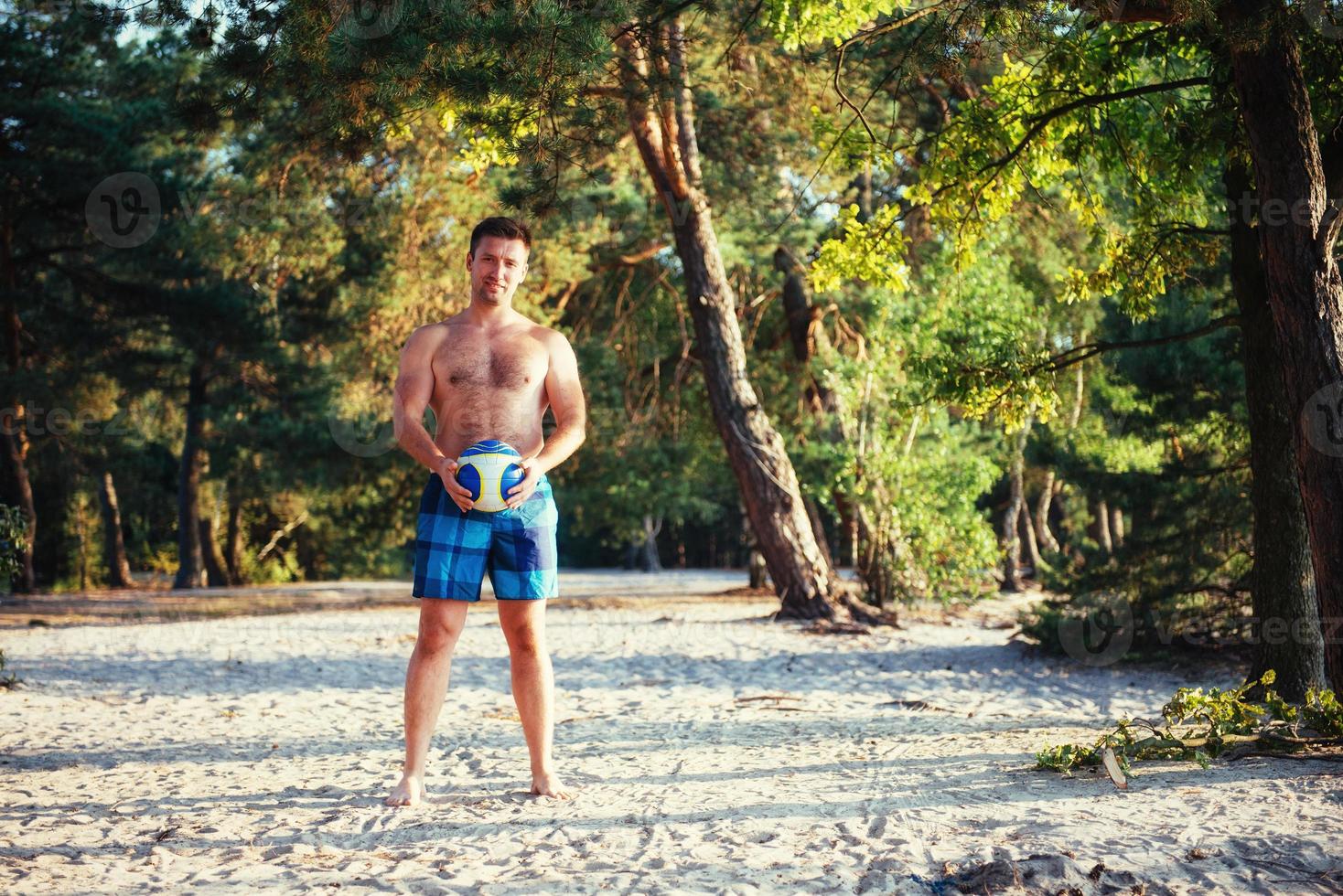young guy playing volleyball on the beach photo