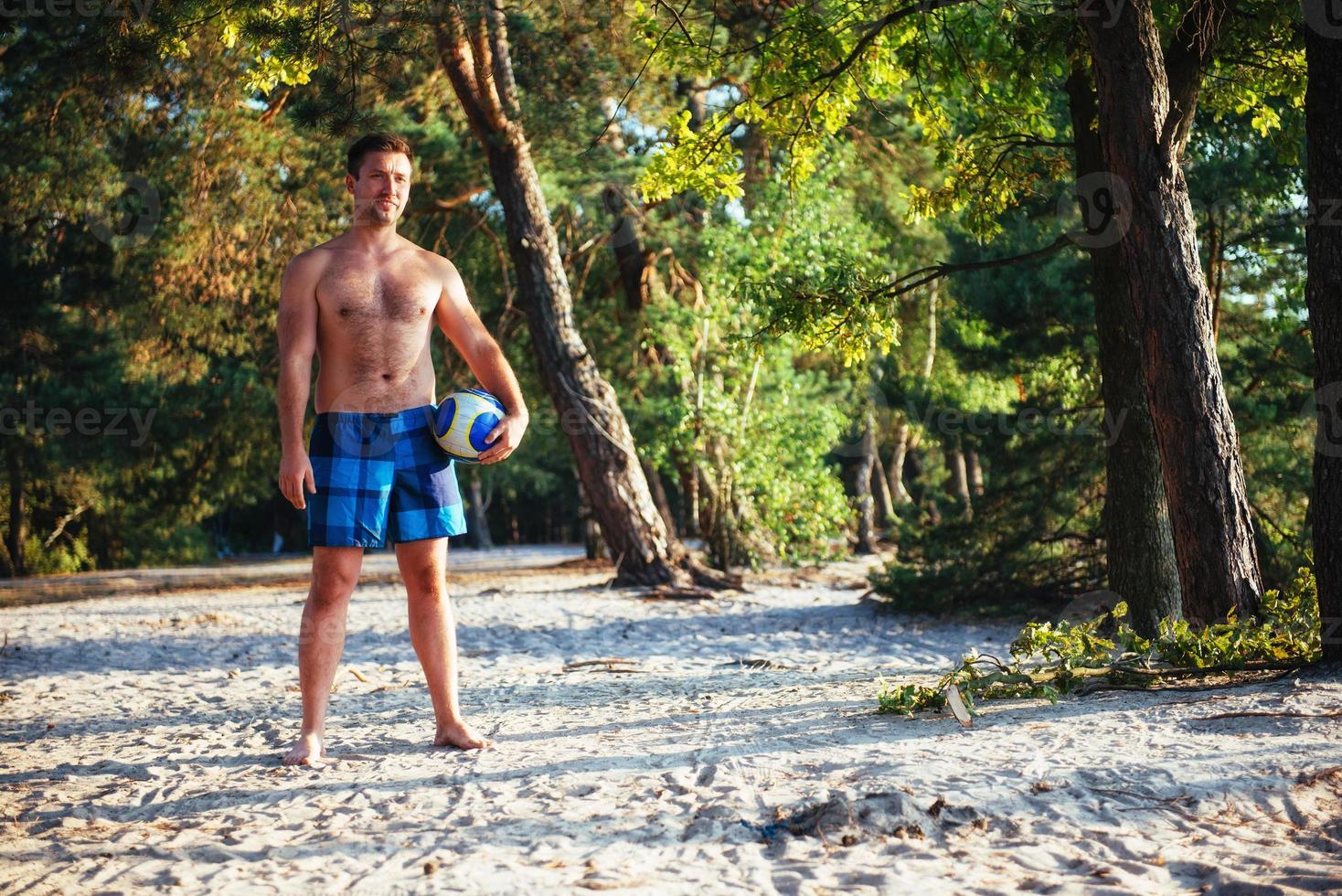 young guy playing volleyball on the beach photo