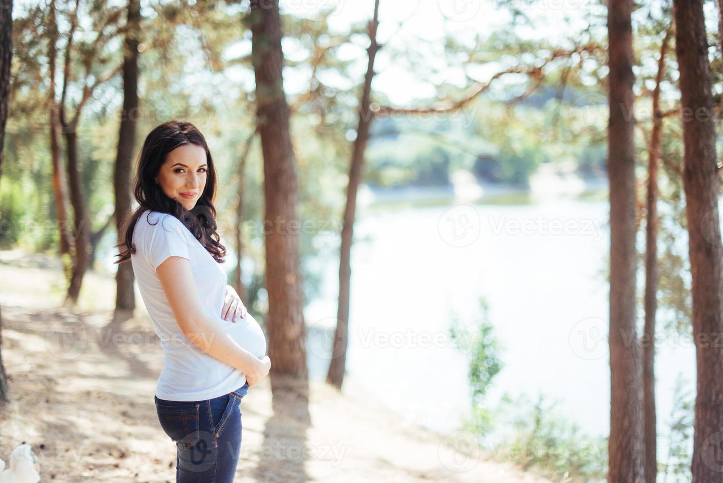 Pregnant Woman holding her hands on  stomach photo