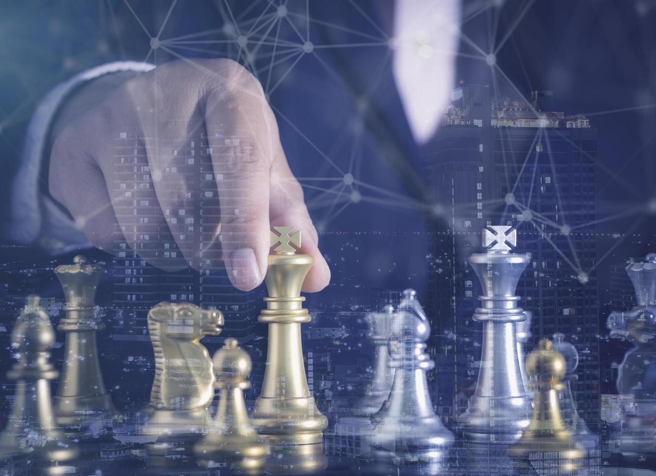 Hand of businessman moving gold king chess figure in competition success with double exposure digital graphic network line connecting diagram business.Strategy, leadership and management ideas concept photo