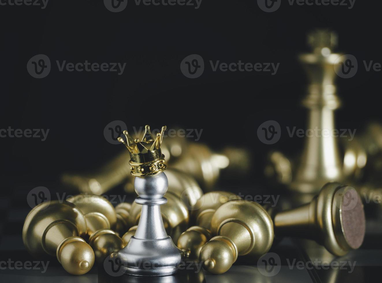 A silver pawn standing crowned in battle chess game on board with gold chess background. To fighting with teamwork to victory, business strategy concept and leader and teamwork concept for success. photo