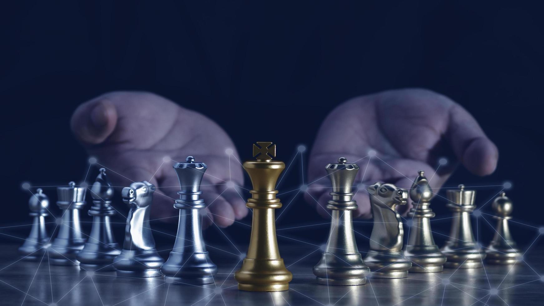 Hand of businessman holding the golden king chess to fighting silver king chess to play successfully in the competition with technolog network background. Management or leadership strategy concept. photo