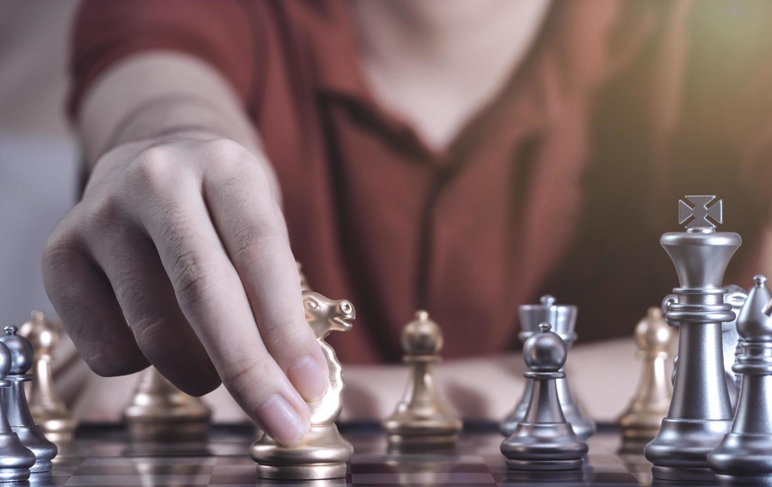 mano de niño confiado que mueve el ajedrez de peón al desarrollo en el juego de éxito de la competencia qué nuevo plan de estrategia, líder y trabajo en equipo, tácticas de aprendizaje en red y concepto de análisis. foto