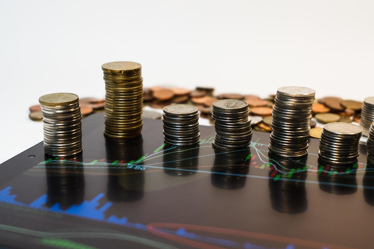 las monedas están dispuestas de manera diferente en la tableta, la inversión es un concepto arriesgado, comercial y financiero. foto