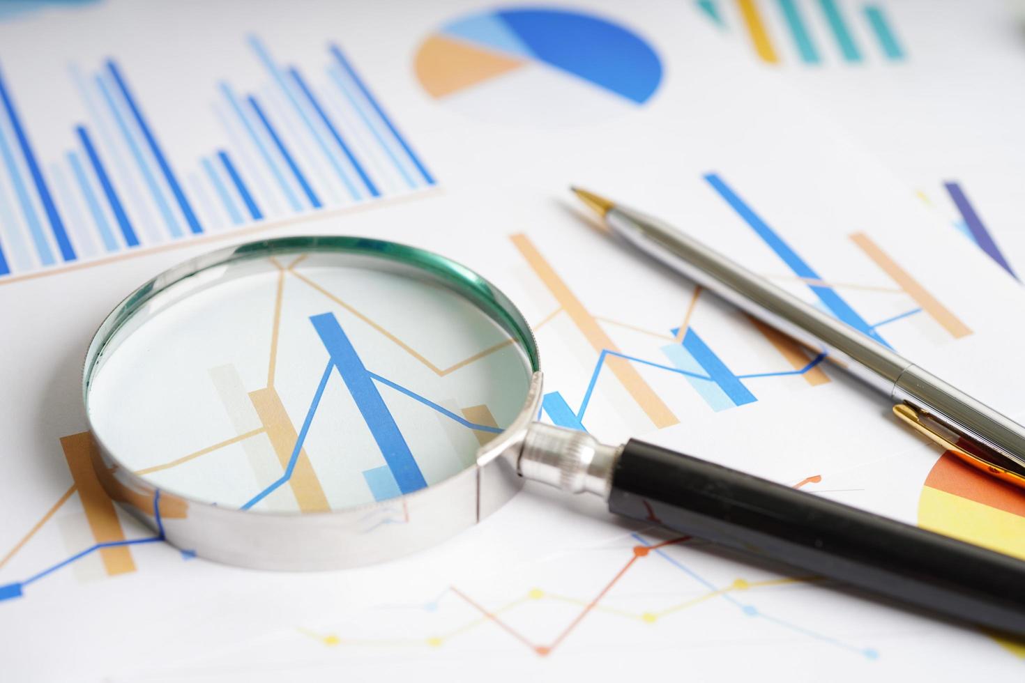 Magnifying glass on charts graphs paper. Financial development, Banking Account, Statistics, Investment Analytic research data economy, Stock exchange trading, Business office company meeting concept. photo