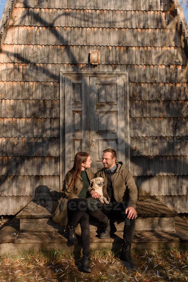 Lovely couple spending autumn day outdoors with their dog photo