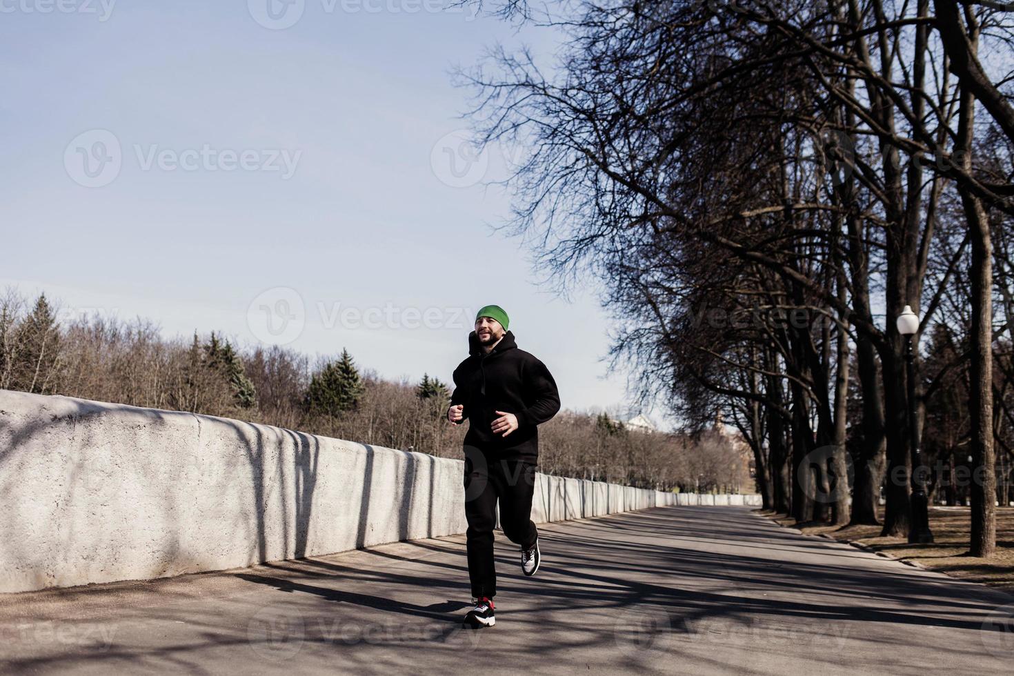 athletic man running at park photo