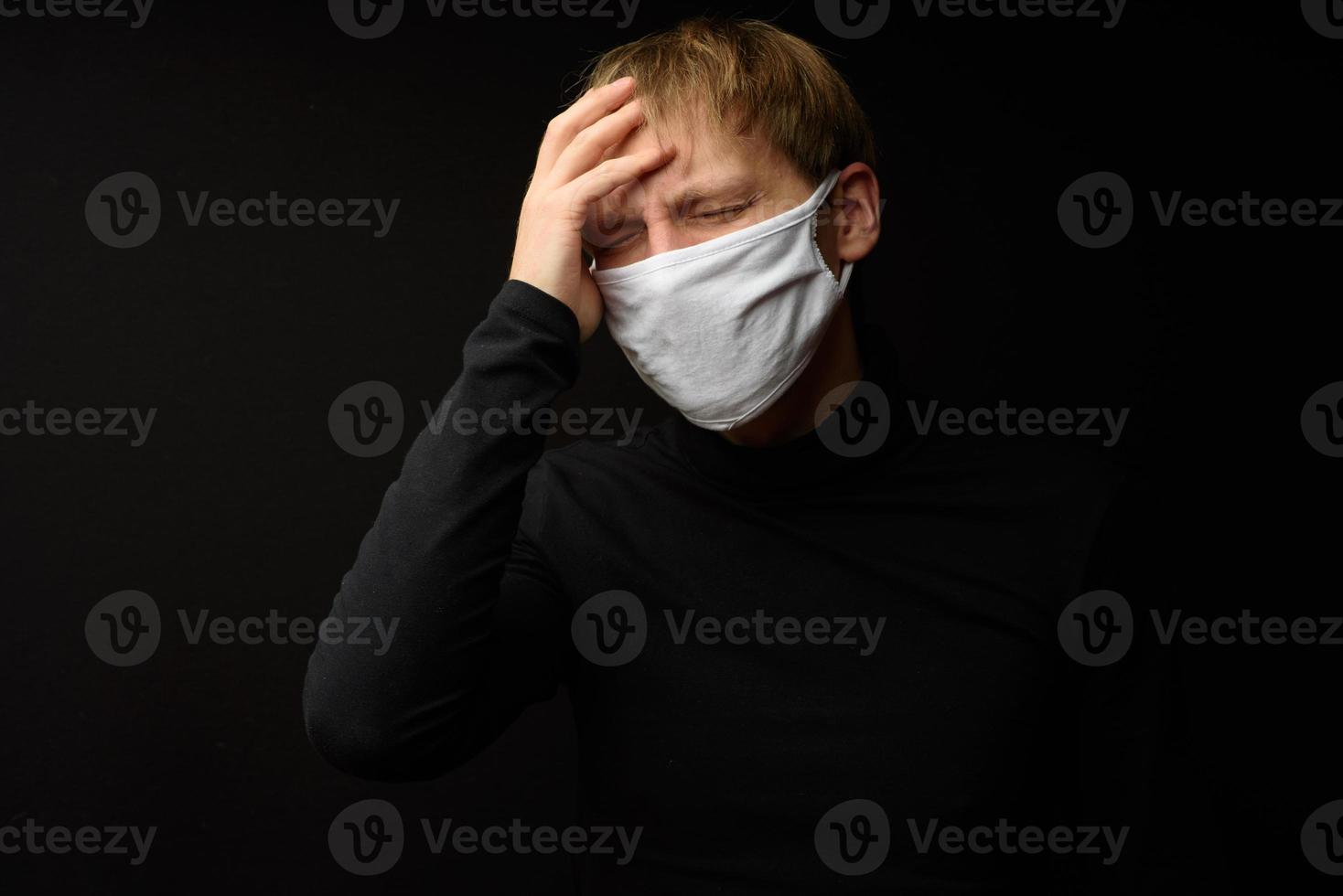 Middle aged man with medical face mask portrait close up illustrates pandemic coronavirus disease on dark background. Covid-19 outbreak contamination concept. photo