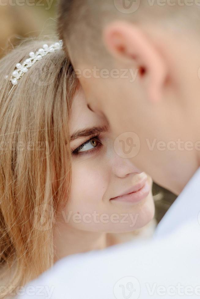 Photoshoot of a couple in love in the mountains. The girl is dressed like a bride in a wedding dress. photo