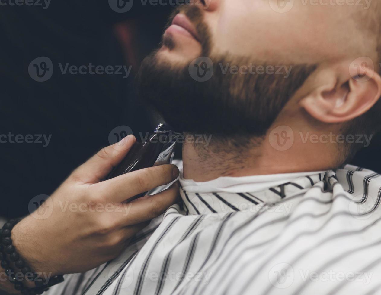 Barber makes beards correction photo
