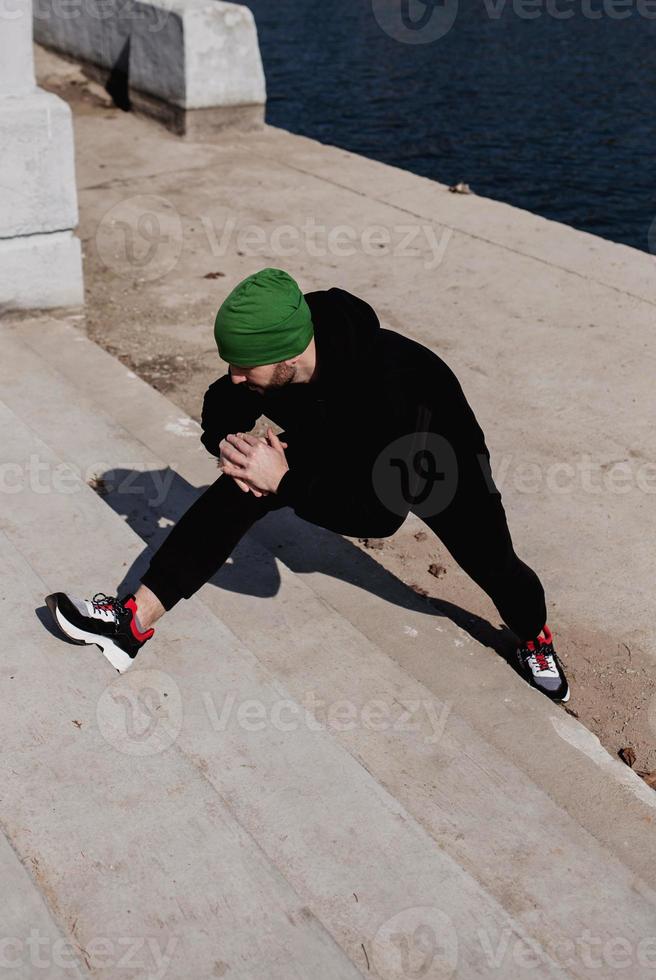 Man runner does stretching exercises photo