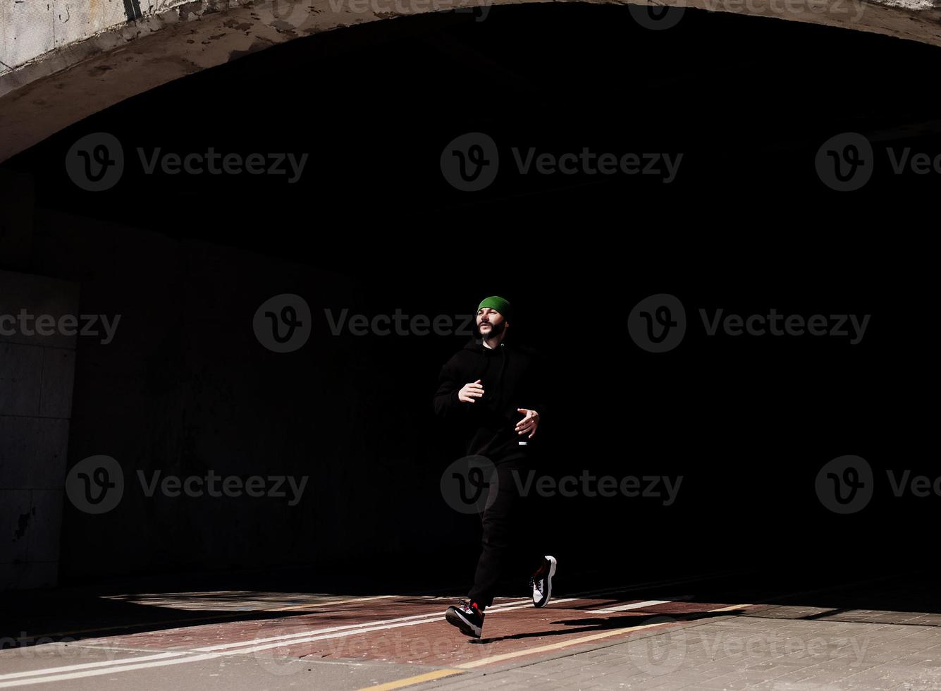 man dressed in sports clothes and running photo