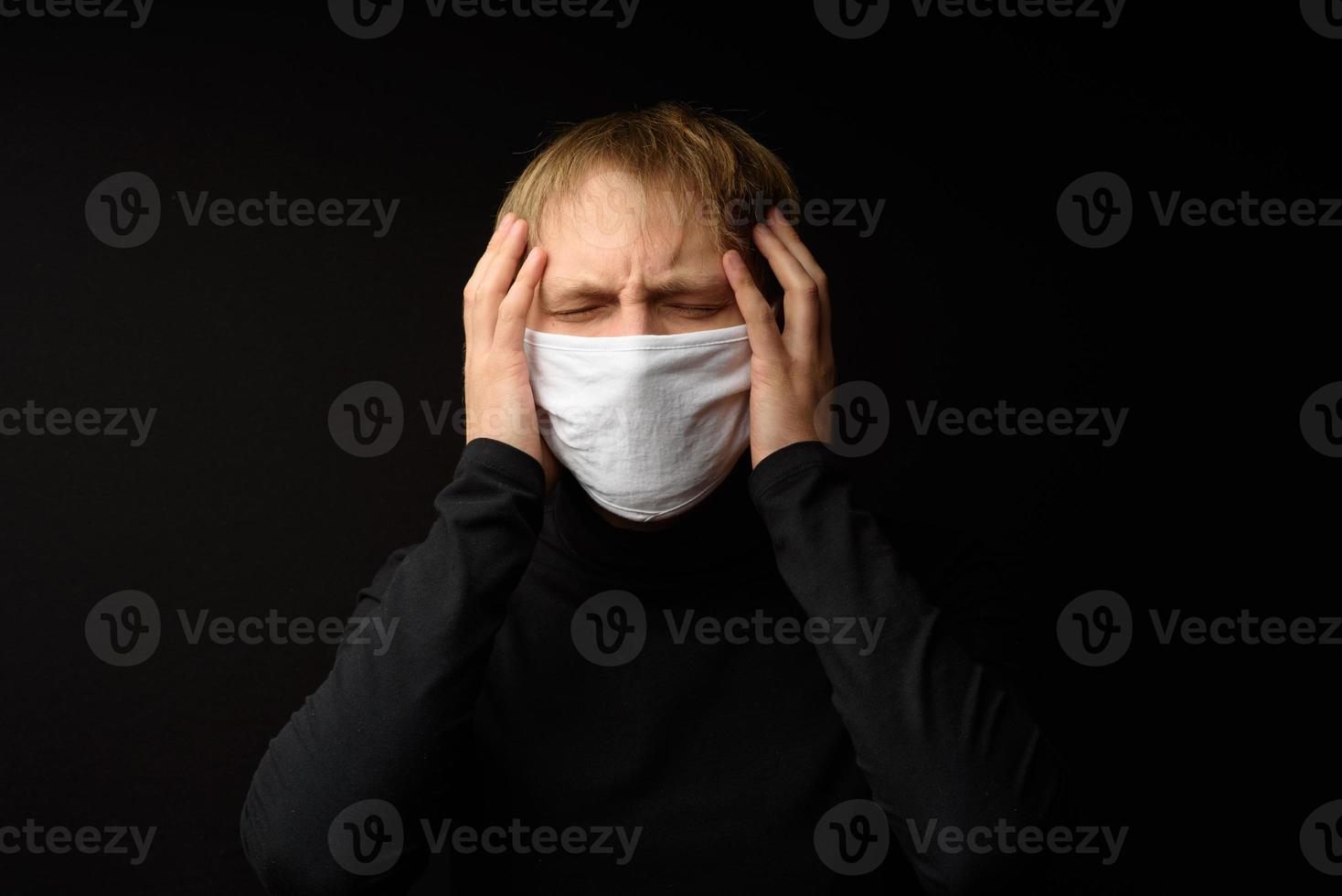 un hombre de mediana edad con un retrato de mascarilla médica de cerca ilustra la enfermedad del coronavirus pandémico en un fondo oscuro. concepto de contaminación por brotes de covid-19. foto