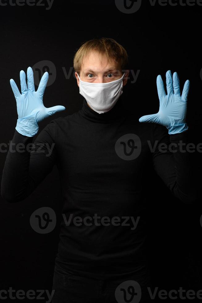 médico con guantes protectores de látex y mascarilla. vista frontal de la cara del hombre con una máscara médica. coronavirus covid-19 y concepto de atención médica foto