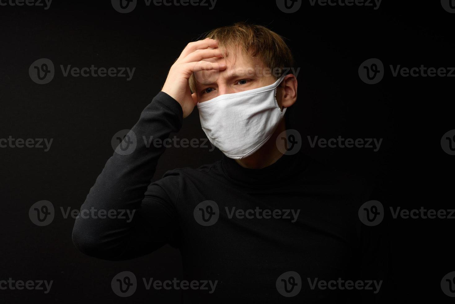 Middle aged man with medical face mask portrait close up illustrates pandemic coronavirus disease on dark background. Covid-19 outbreak contamination concept. photo