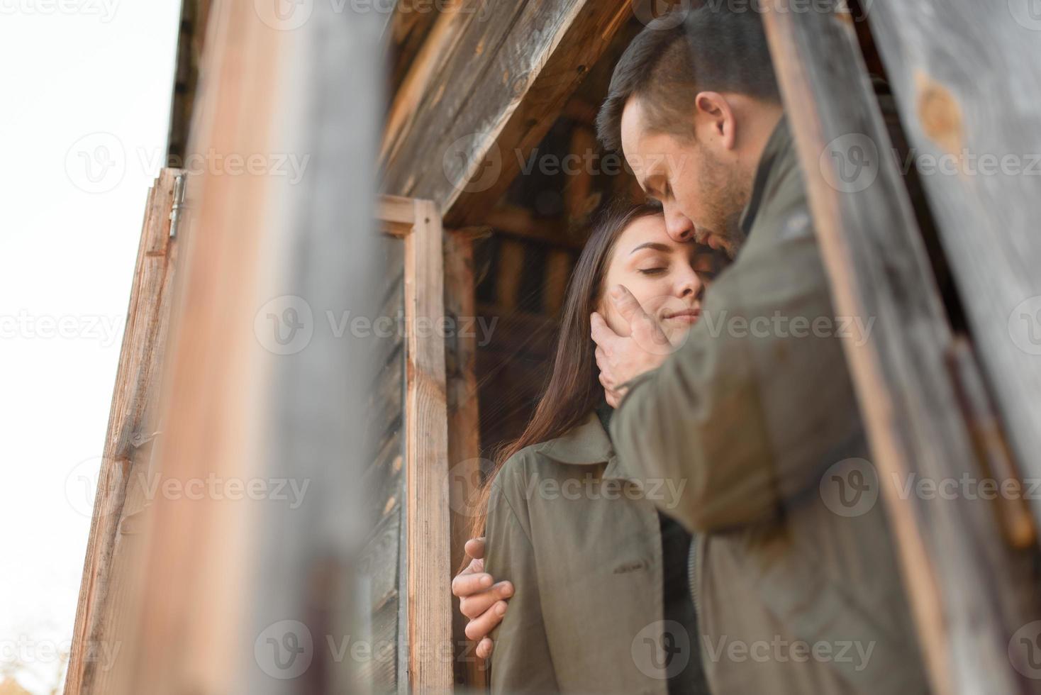 couple in love looks out of the window, wooden house. The concept of buying new housing for young families. photo