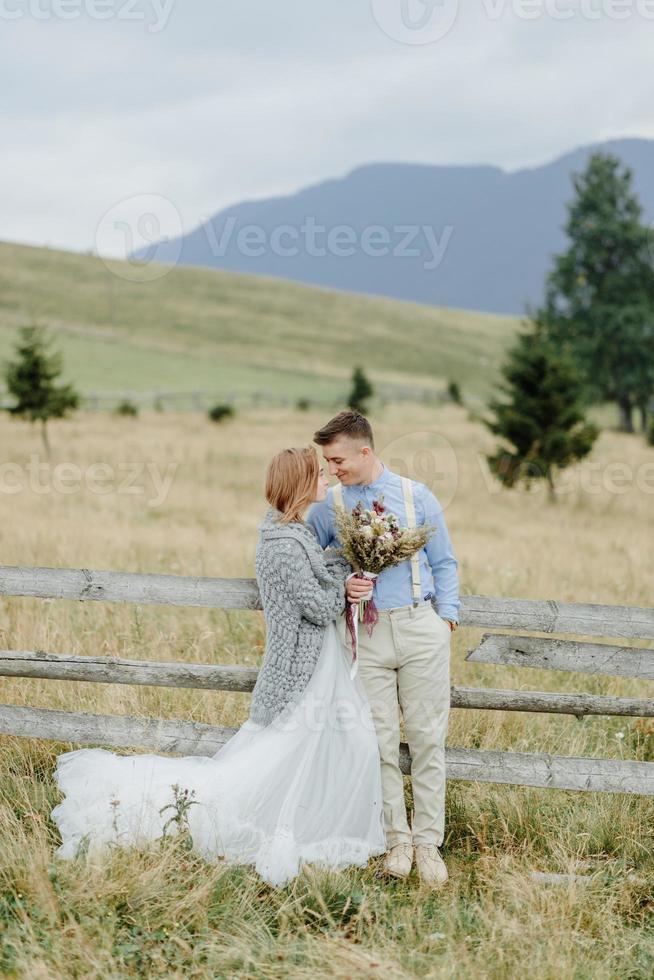 Photoshoot of the bride and groom in the mountains. Boho style wedding photo. photo