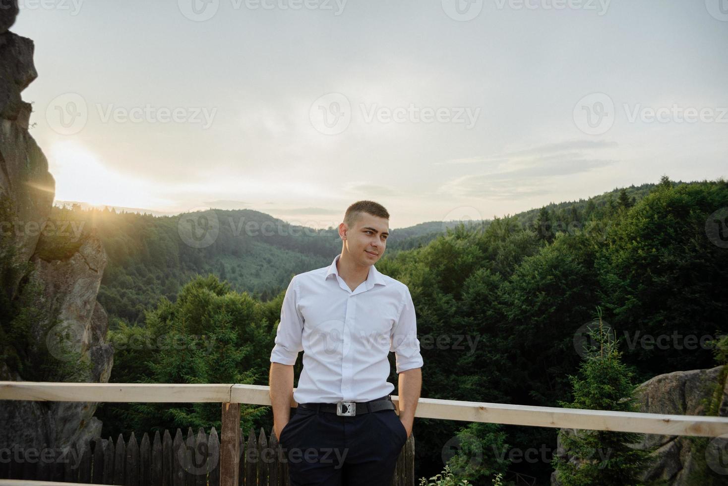 Portrait of a young groom shot in the mountains photo