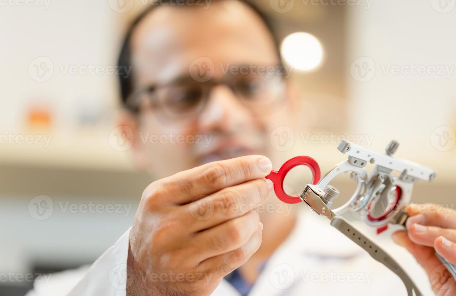 oftalmólogo con marco de prueba de optometrista en clínica oftalmológica, optometrista revisando marco de prueba en tienda óptica foto