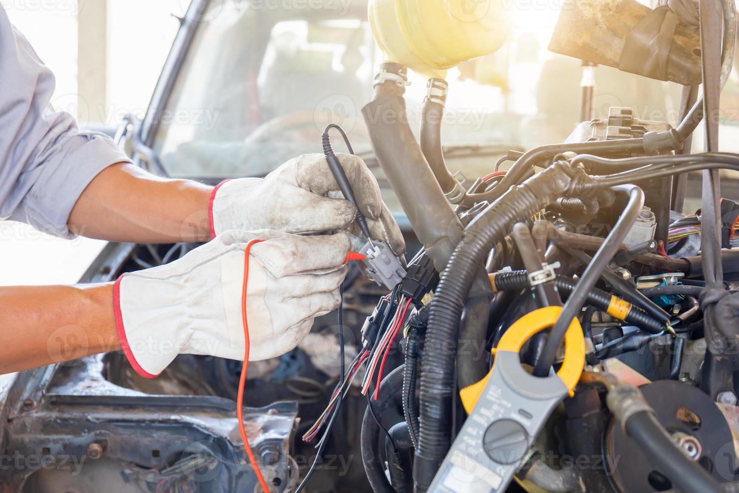 Auto mechanic working on car engine in mechanics garage, Repair and Maintenance service photo