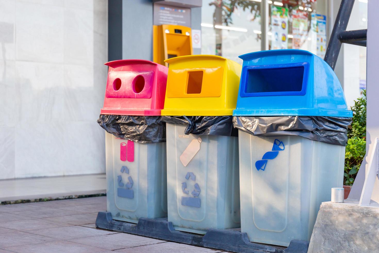 grupo de papeleras de reciclaje de colores, papeleras de diferentes colores para la recogida de materiales reciclados. cubos de basura con bolsas de basura de diferentes colores. concepto de medio ambiente y gestión de residuos. foto