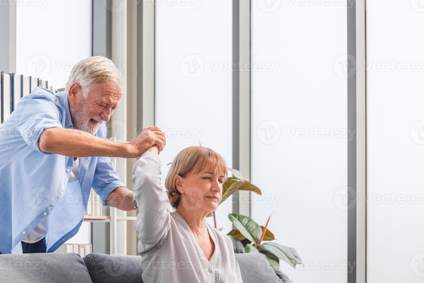 Portrait of happy senior couple in living room, senior man is doing his wife massage, they are resting at home, Happy family concepts photo