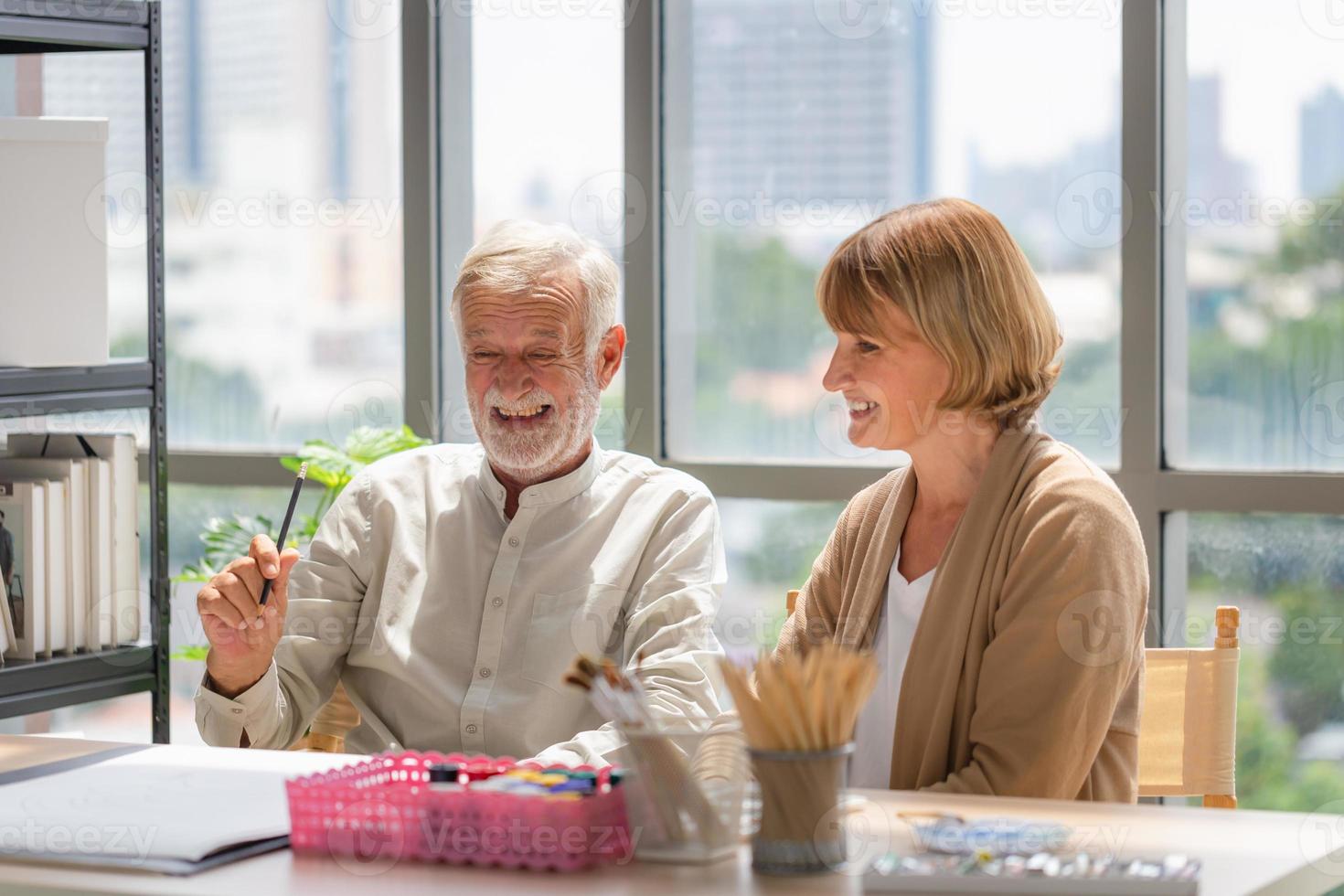 Portrait of Senior couple painting on a canvas in living room, Older man and woman drawing together on a canvas at art studio, Happy retirement concepts photo