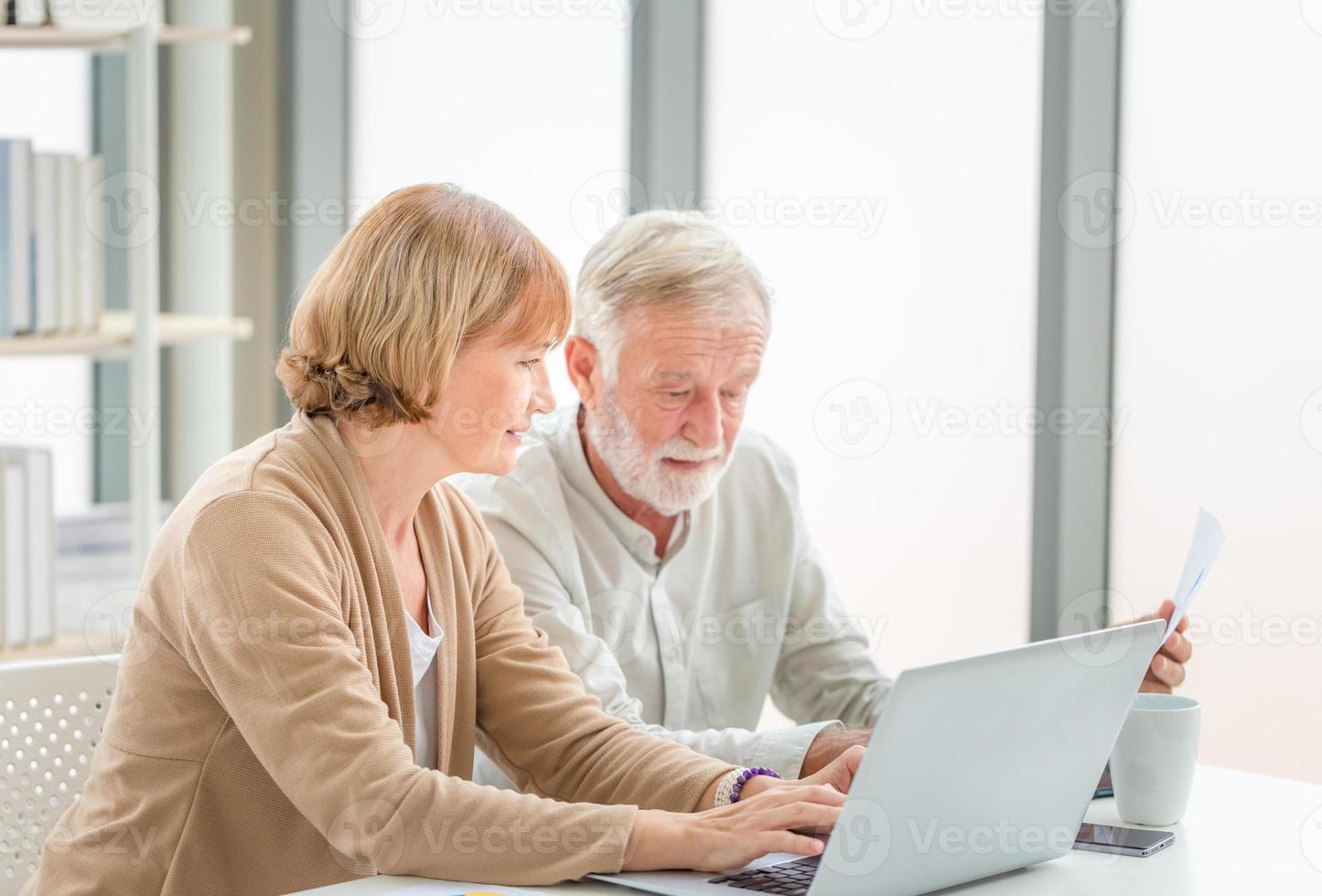 pareja mayor revisando sus facturas, ancianos jubilados familia vieja leyendo documentos foto