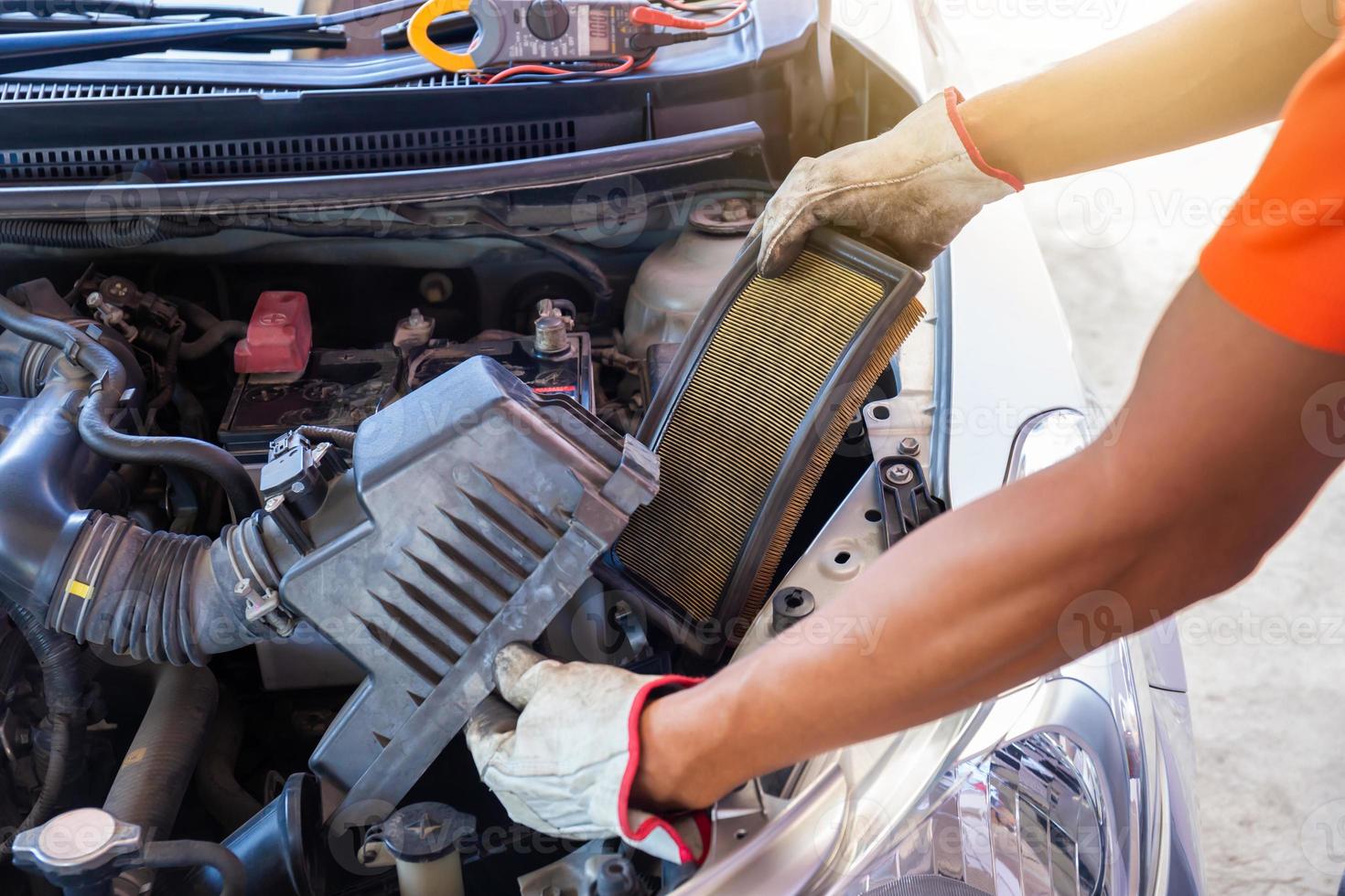 mecánicos automáticos revisando el filtro de aire del camión en la sala del motor, técnico haciendo la lista de verificación para reparar el motor del camión en el garaje foto