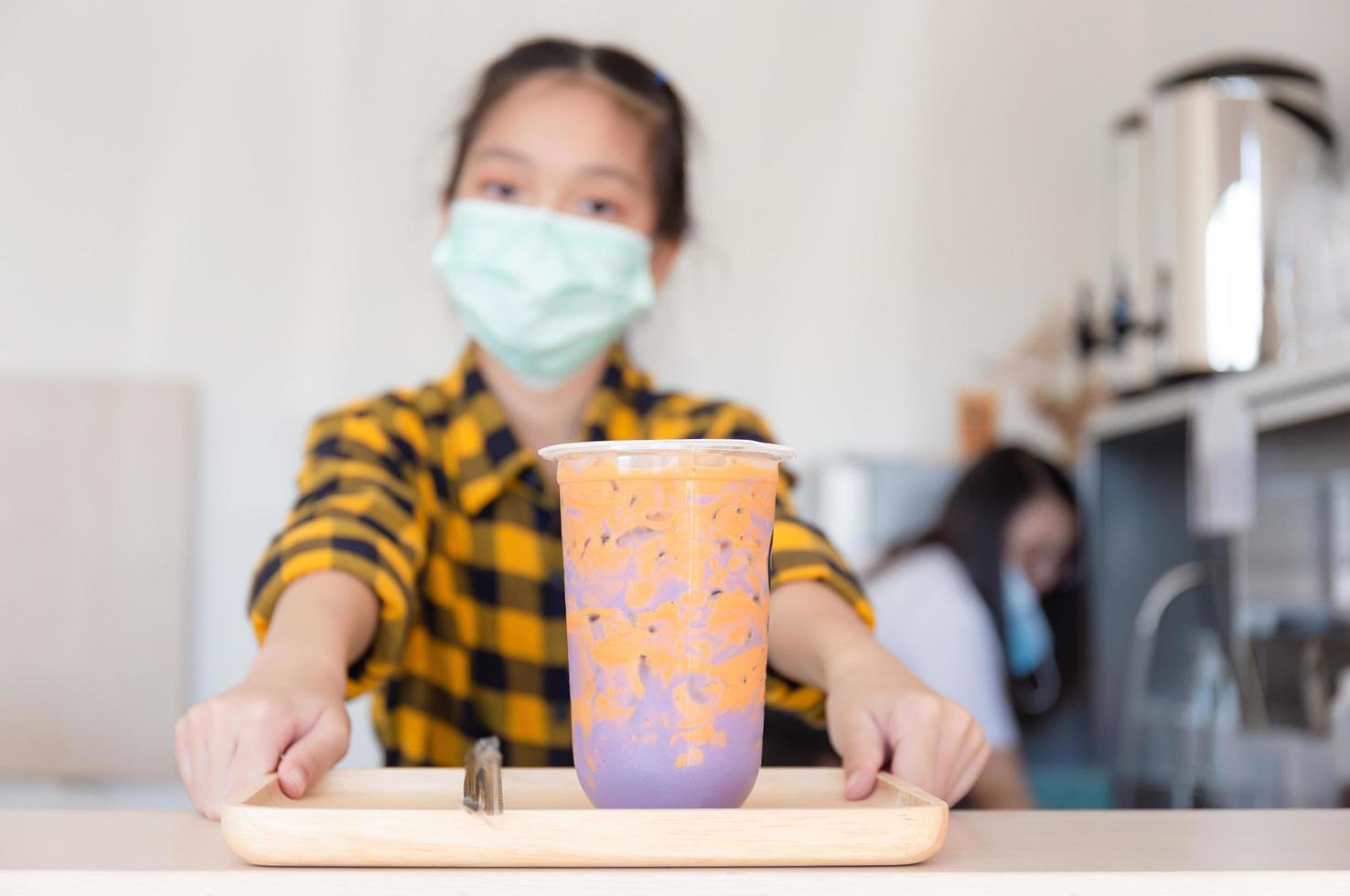 niña lista para dar servicio de té de boba en la tienda moderna, niñita aprendiendo a servir, concepto de educación foto